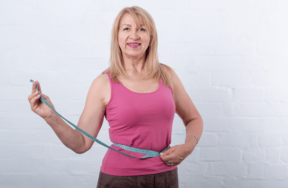 An old woman measuring her waiqt