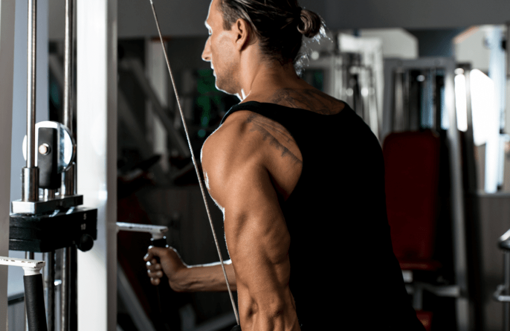 A man performing tricep pushdowns properly at the gym with a machine