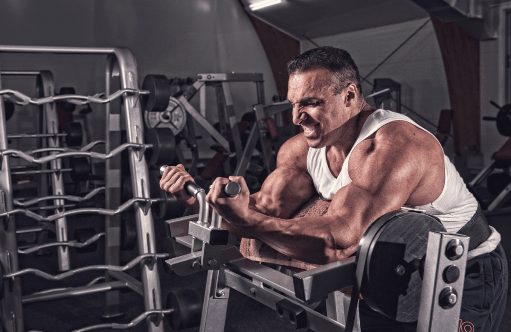 A man doing spider curls with a specific machine