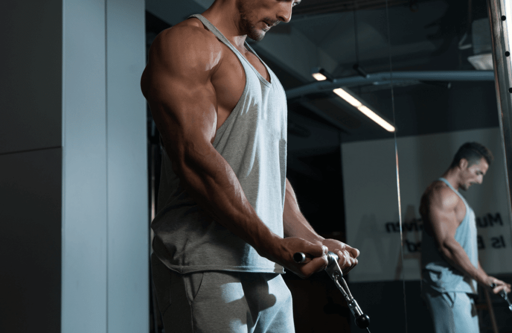 A man performing a cable exercise because he knows how to get wider biceps