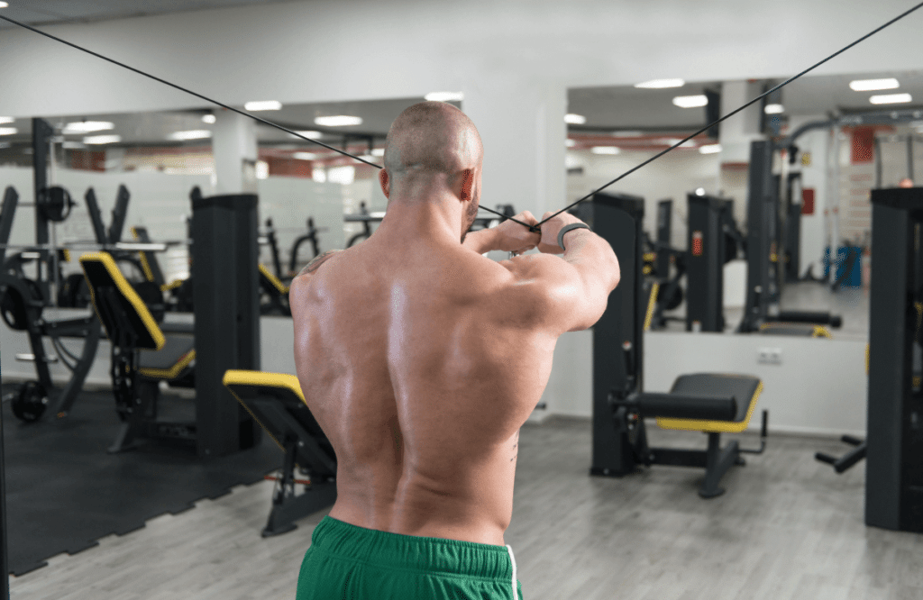 A man doing cable back workouts at the gym using both arms