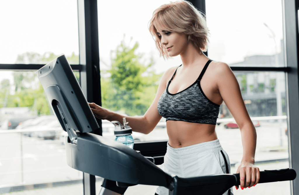 A woman at home using one of the best treadmills with Netflix