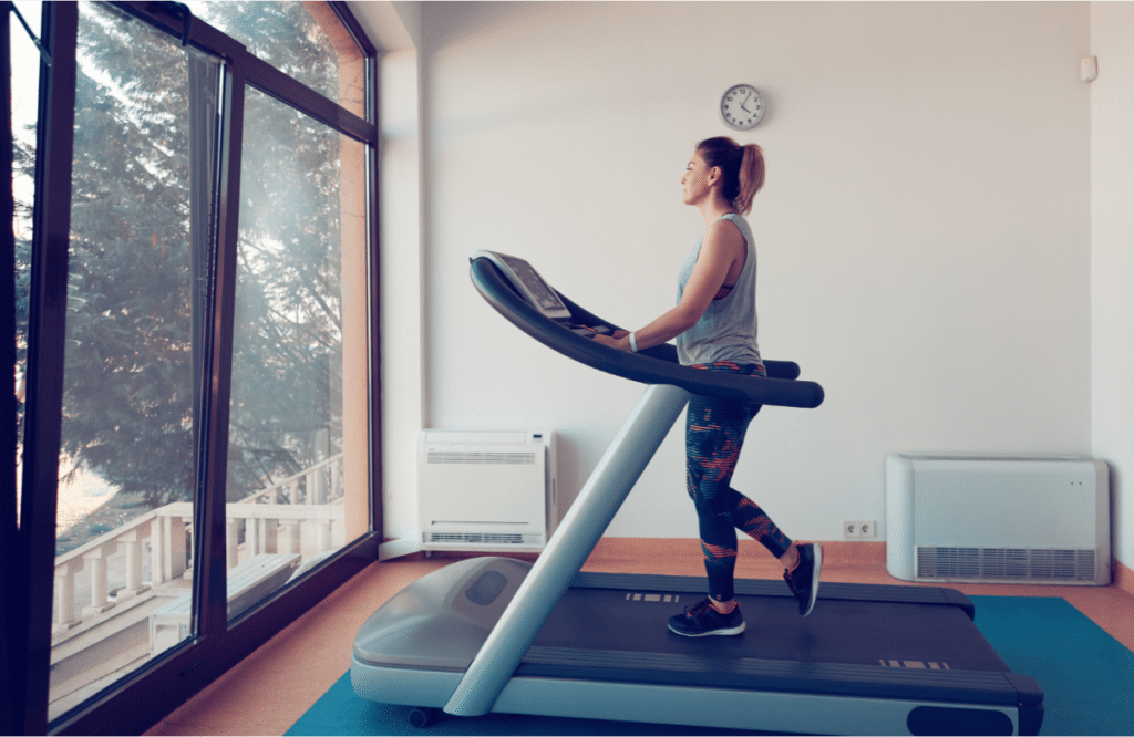 A woman working out at home on one of the best treadmills with Netflix