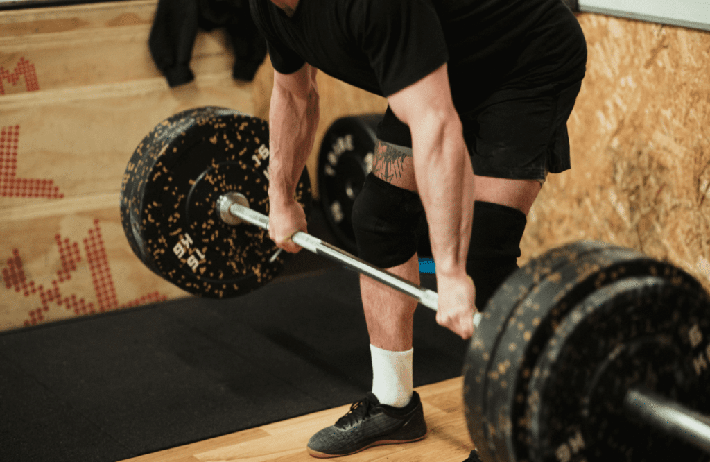An athlete at the gym performing deadlifts after using a deadlift max calculator