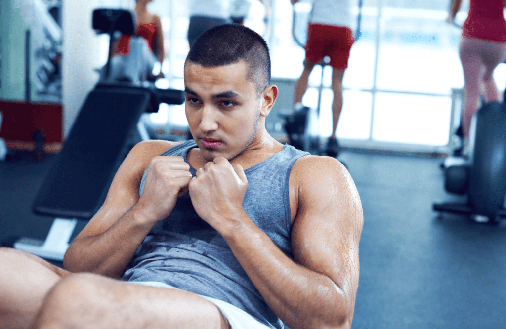 A muscular man doing oblique crunches at the gym