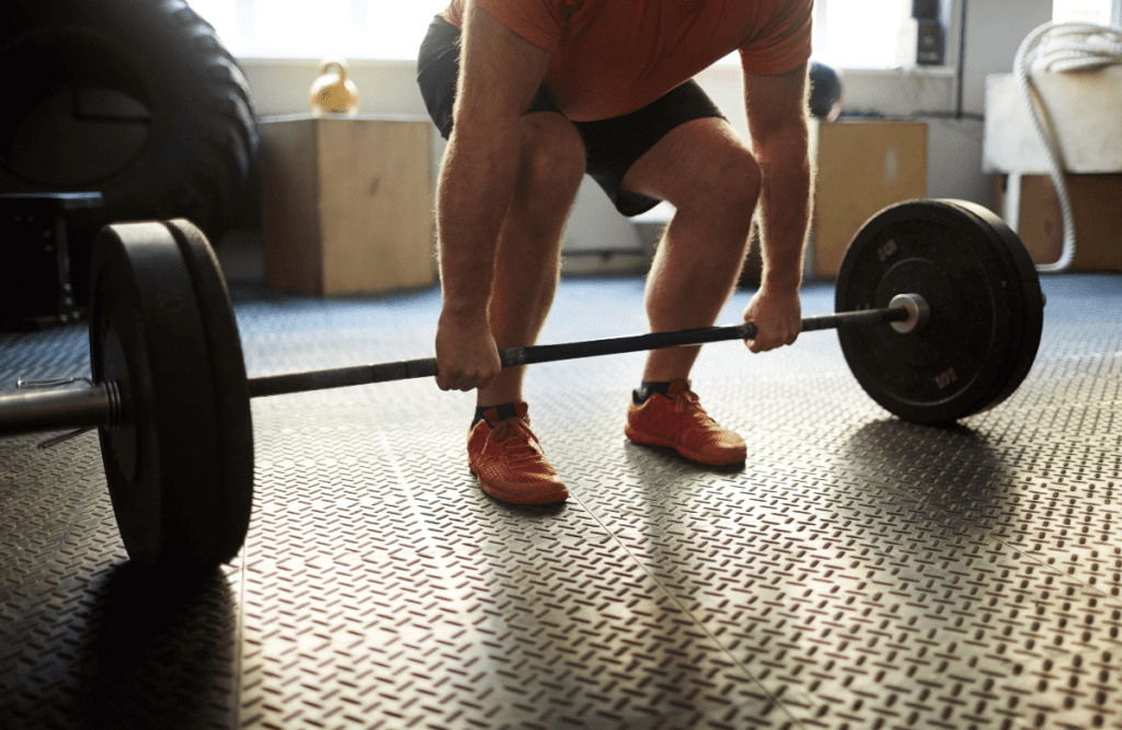 A man preparing his barbell before deadlifting