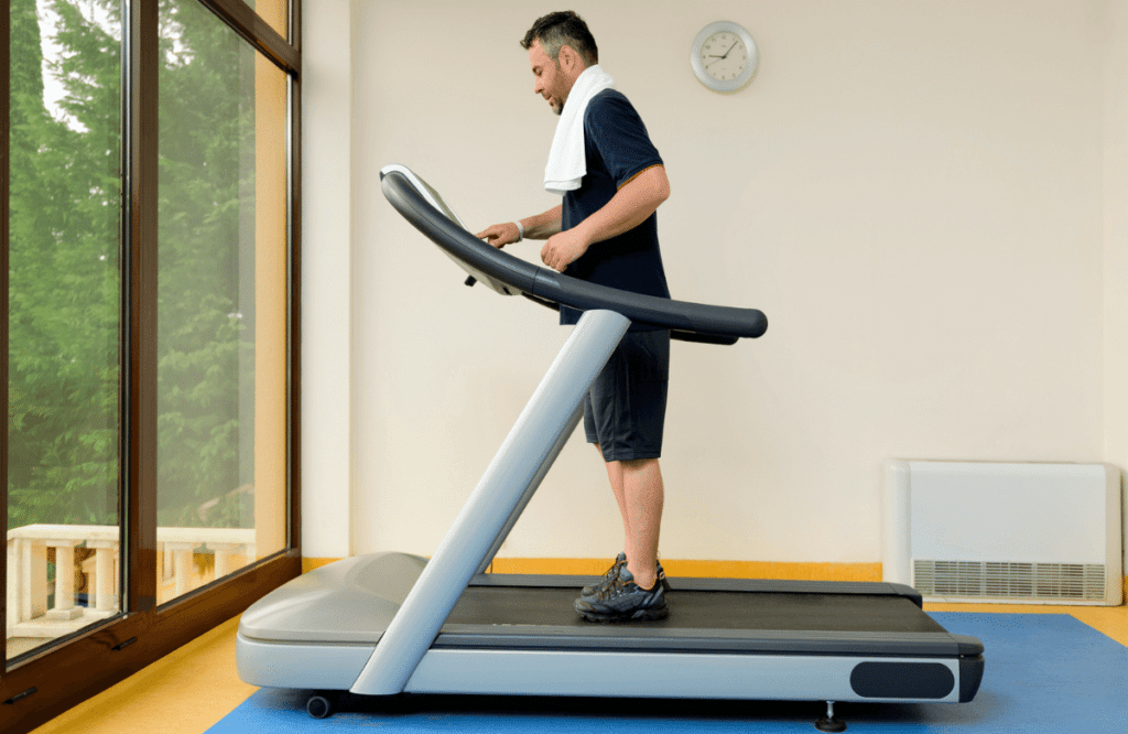 A man at home who is using his treadmill on carpet