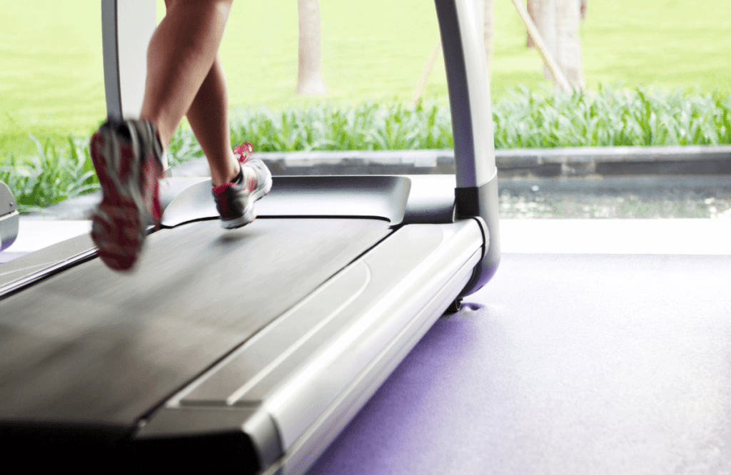 A woman at home who is using her treadmill on a carpet