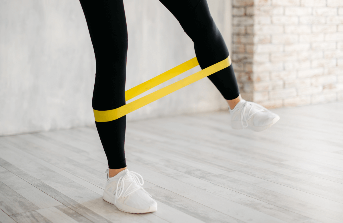A woman performing resistance band workouts at home