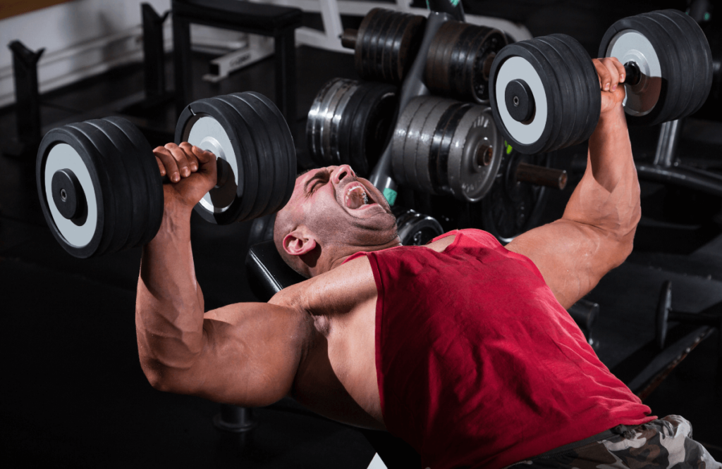 A man being injured during his shoulder workout with dumbbells