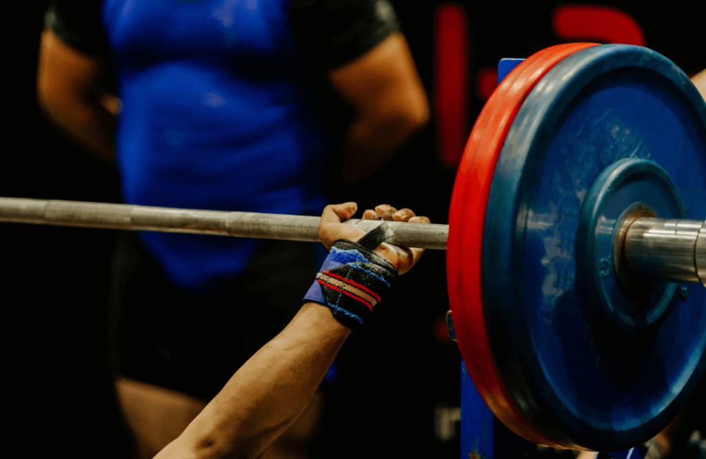 An athlete lifting a barbell with bumper plates on it