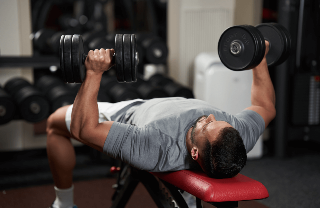 A man doing triceps workout using dumbbells on a bench
