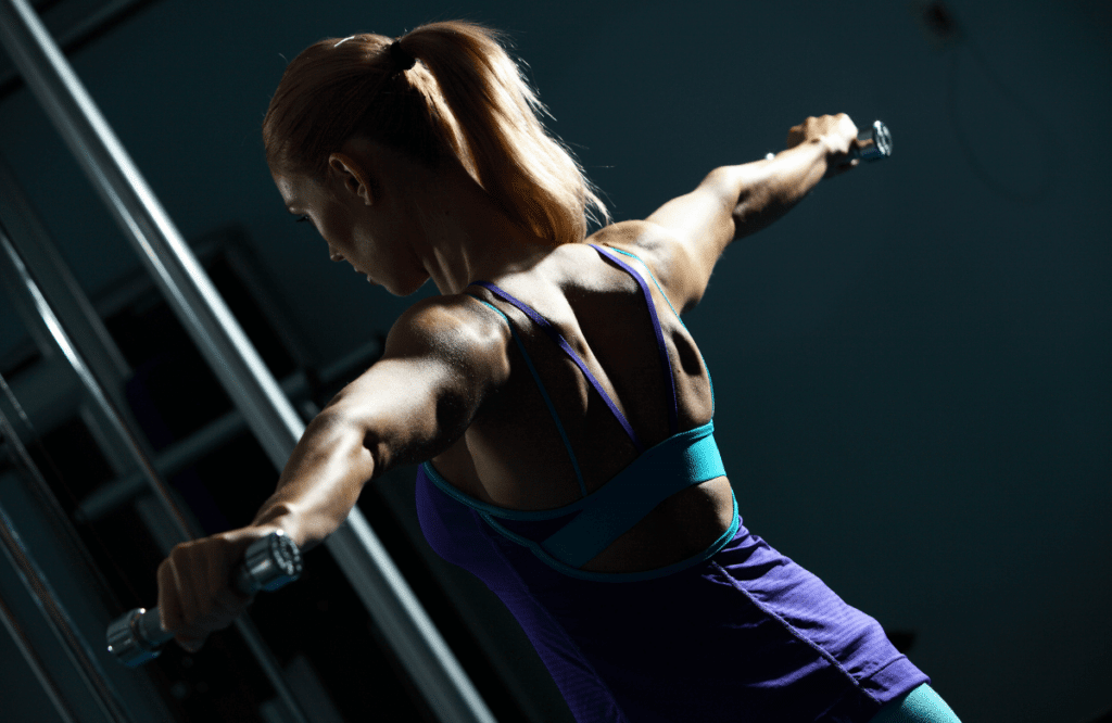 A woman doing shoulder workout with dumbbells