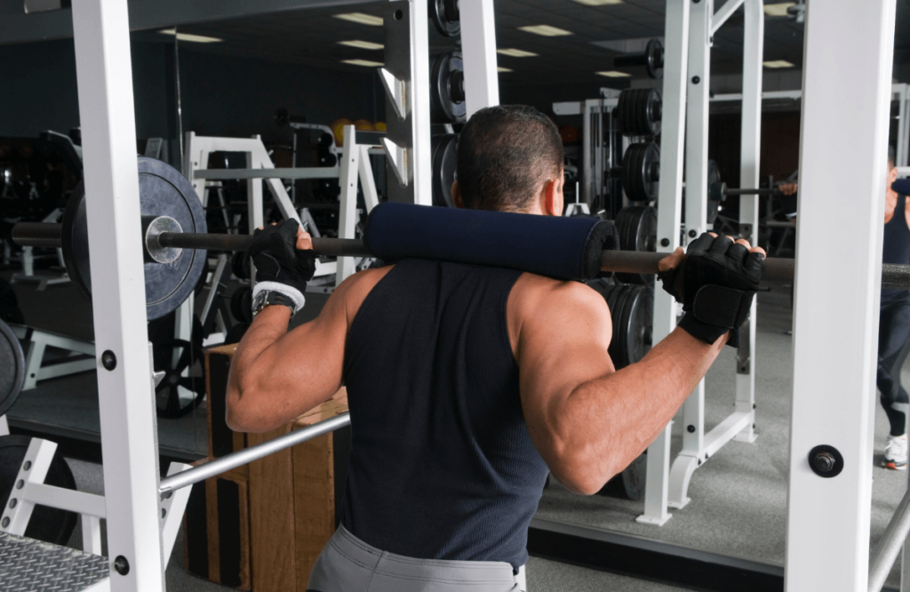 A man using a folding squat rack at the gym