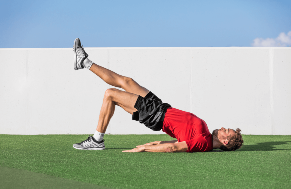 A man doing glute stretches outside