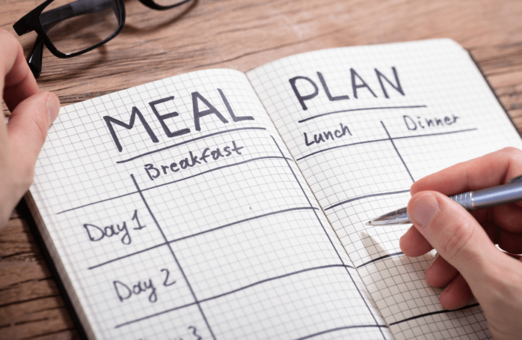 A man creating a lean bulk meal plan with a book