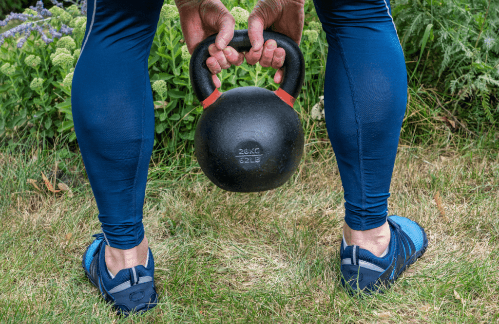 A woman using the best kettlebells to workout in her garden