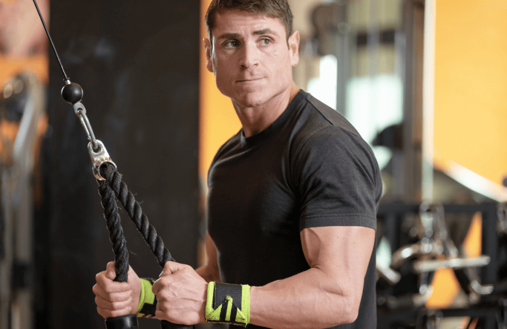 A muscular man doing cable tricep extensions