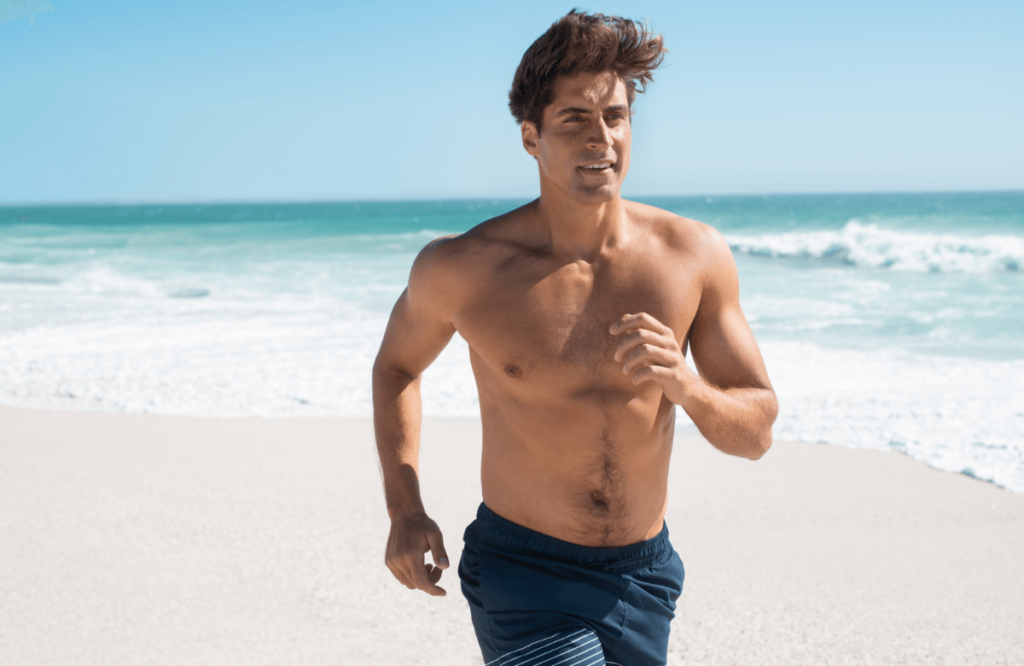 un homme torse nu court sur une plage