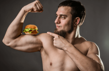 Un homme musclé avec un burger sur son biceps