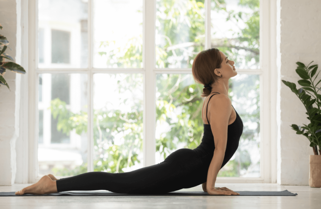 Une femme réalise la posture du yoga, un exercice d'étirement des abdos