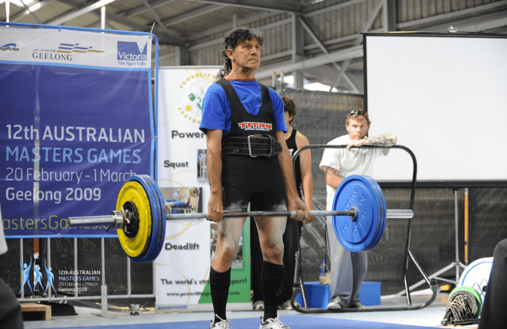 A strong man performing deadlifts at a competition