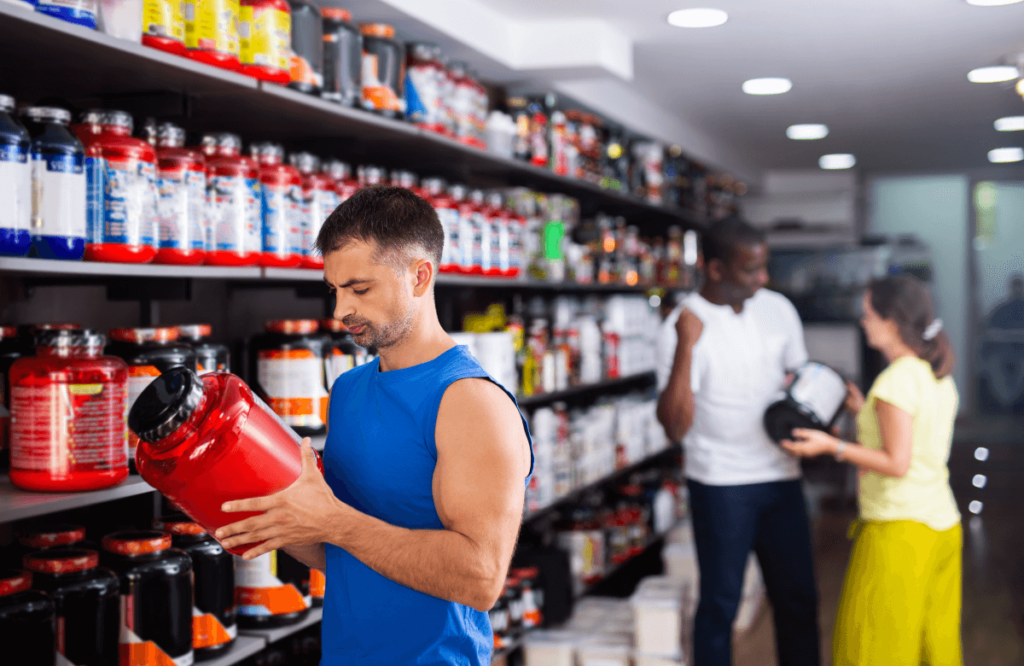 A man reading the ingredients of pre-workout boxes