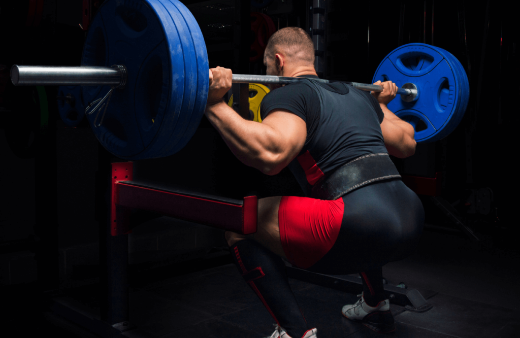 A weightlifter lifting plates with a safety squat bar