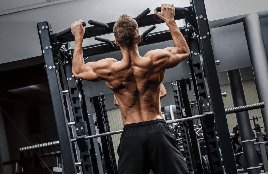 A strong man doing pull-ups, which is one of the best workouts for lats