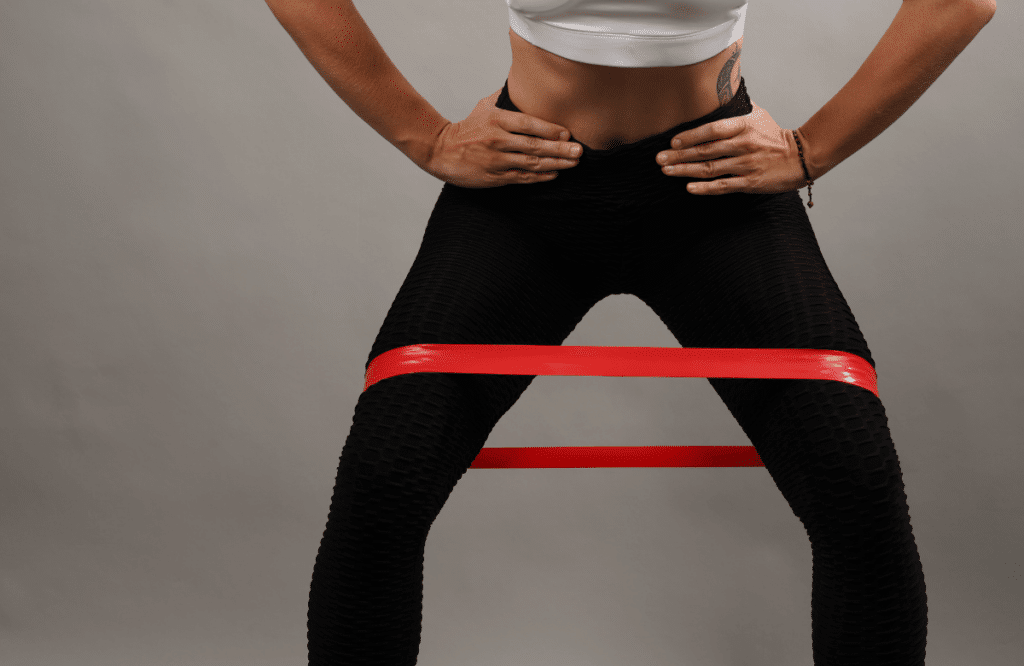 A woman performing a good morning workout variation using a resistance band