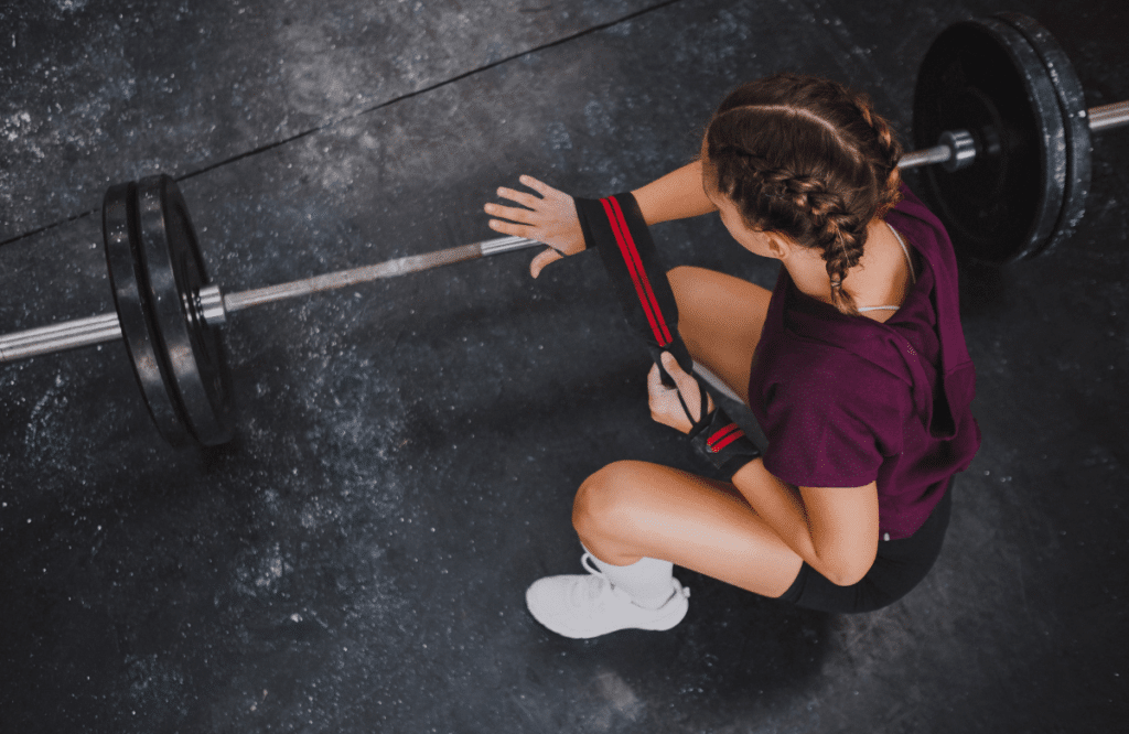 A woman wrapping wrist wrap before deadlifting