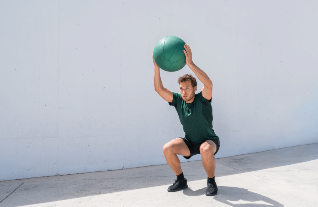 A man doing the best exercise to burn belly fat with a medicine ball