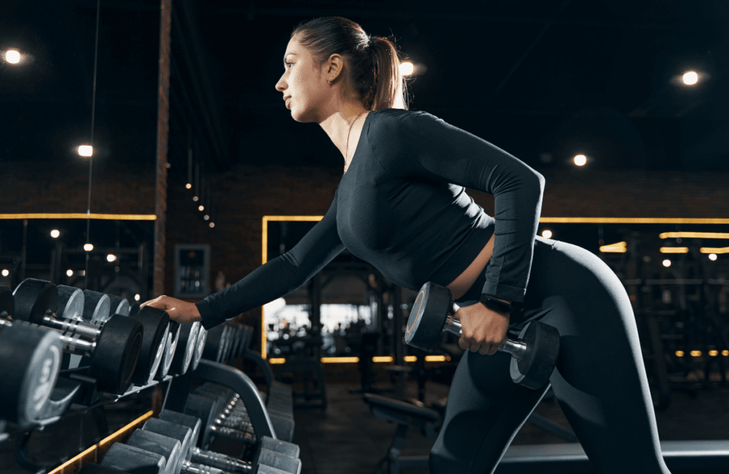 A woman knowing how to do bent over rows variations with dumbbells