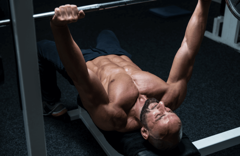 A muscular man doing bench presses to lose weight