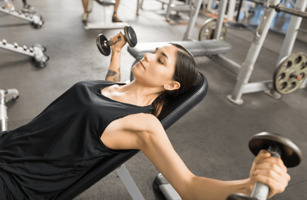 A woman performing incline chest flys at the gym