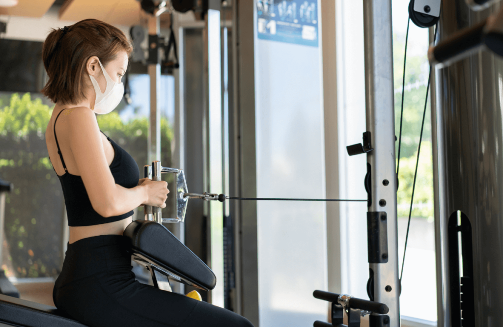 A woman performing cable arm workouts at the gym