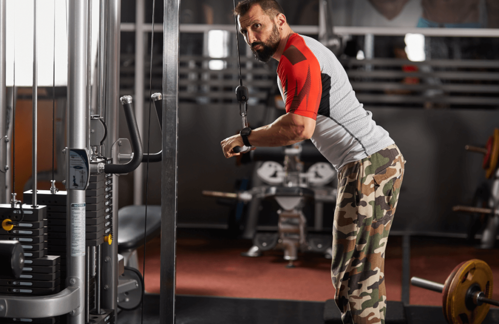 A man targeting triceps during a cable arm workout