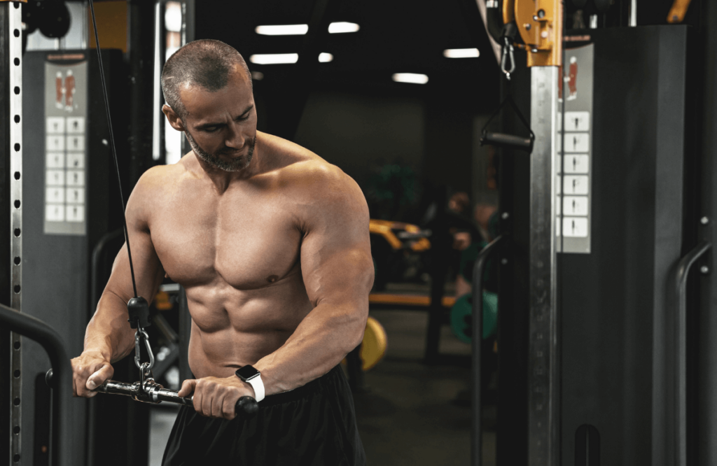 A strong man doing cable arm workouts