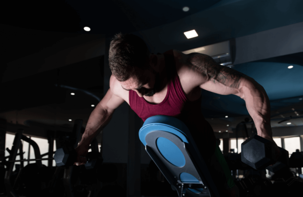 A man doing dumbbell back exercises on a bench