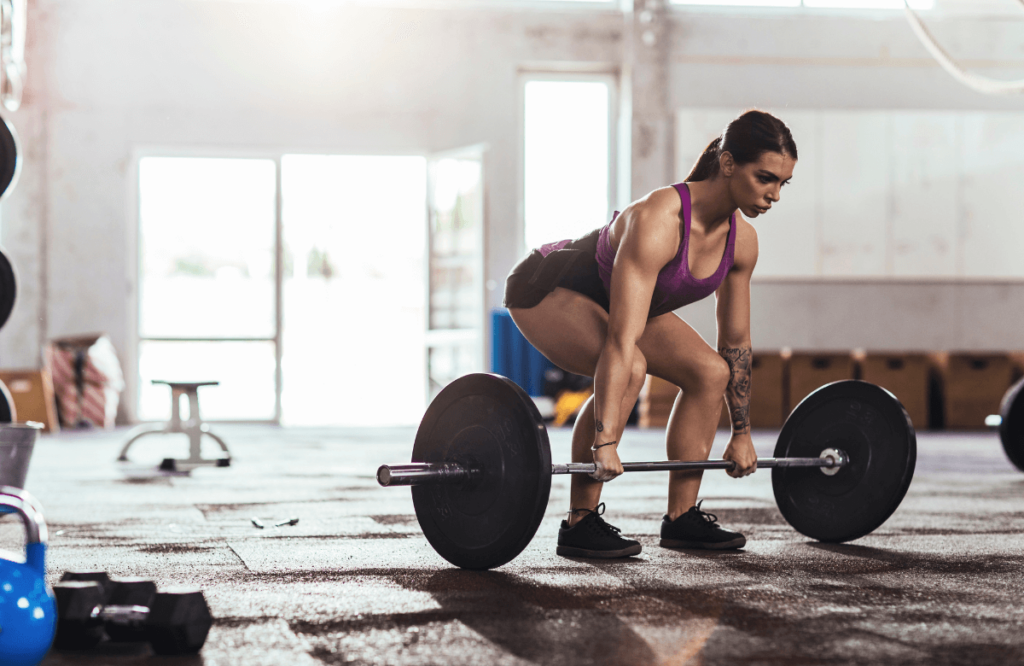 A strong woman wearing the best weightlifting shoes at the gym