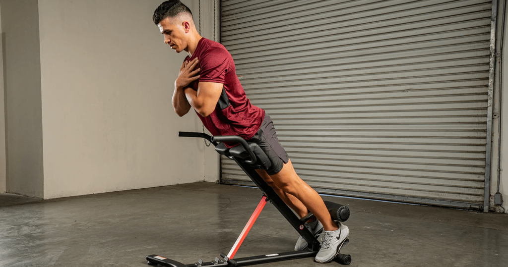 Man does back extensions on roman chair