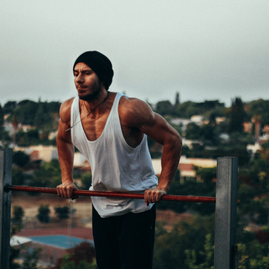 A man does muscle ups in a playground