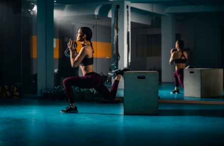 A woman does split squats in a gym, a great alternative to squats