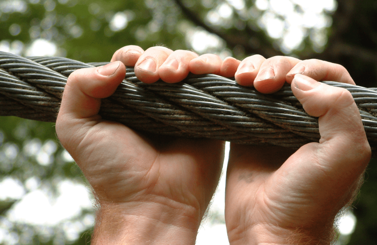 Man holding a wire thanks to awesome grip strength