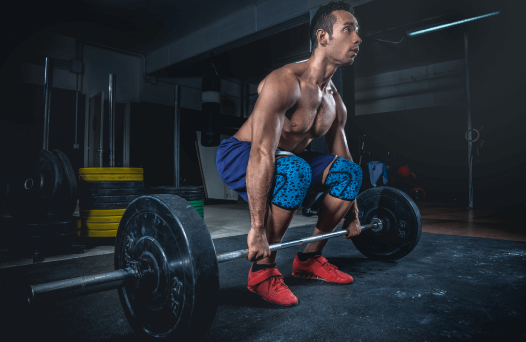 A fit man doing deadlifts in a gym