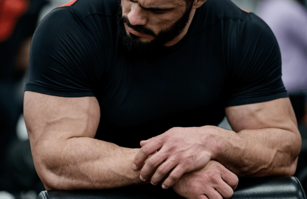 Un homme musclé regarde ses biceps