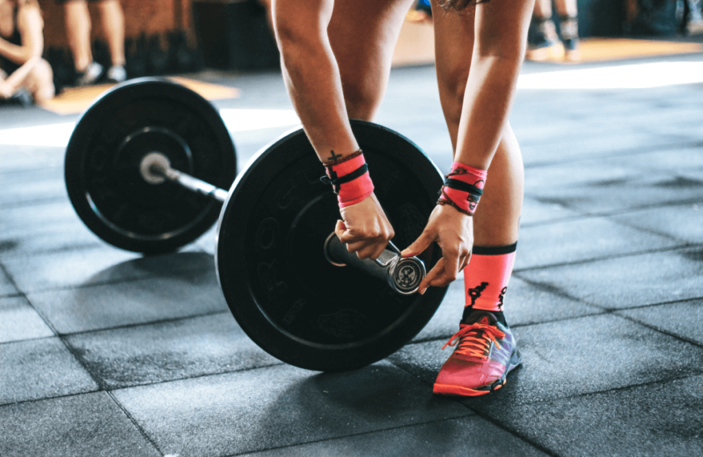 A woman sets-up a barbell for lifting