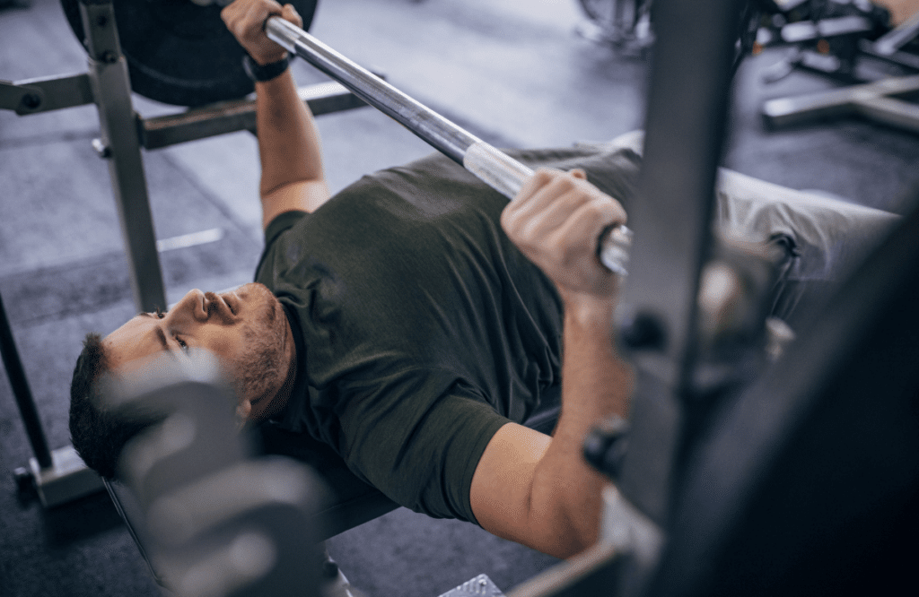 A man with army shirt does bench press