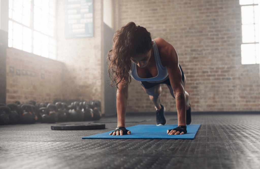 A muscular woman does push-ups