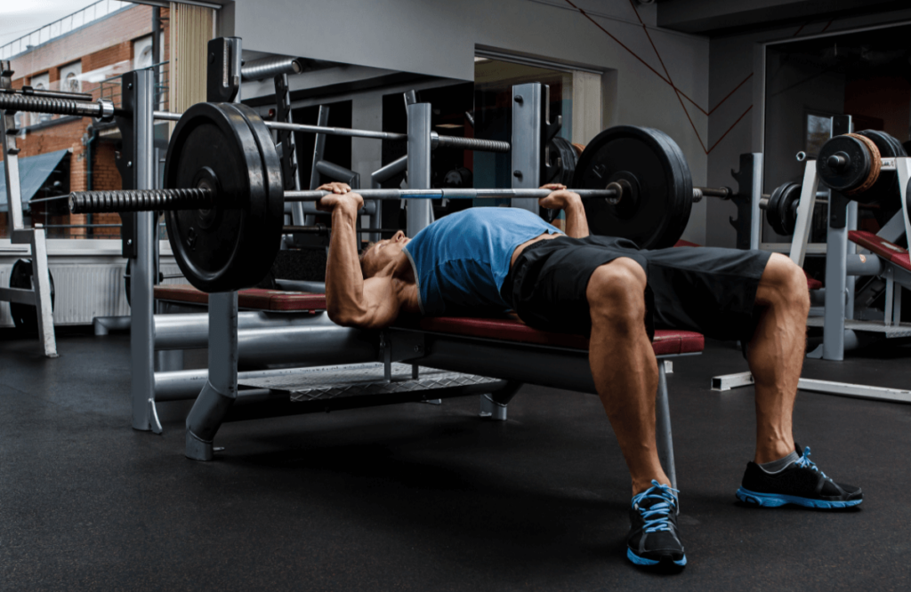 A man does suicide grip bench press in a gym